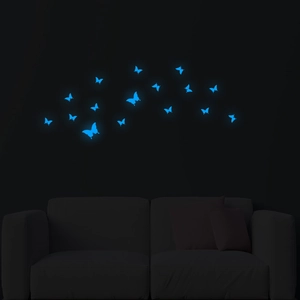 Luminous blue butterfly wall stickers glowing in the dark above a living room sofa