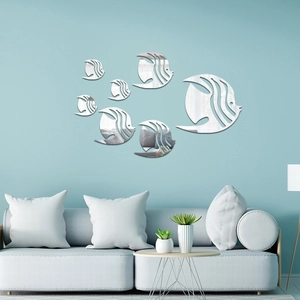 Close-up of seven acrylic fish mirror wall decals in a modern blue living room setup