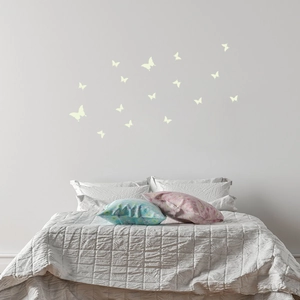 Detailed view of luminous butterfly wall stickers arranged on a cozy bedroom wall