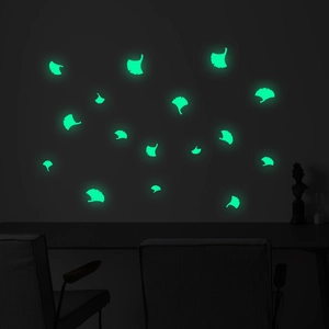 Luminous ginkgo leaf wall stickers glowing in fluorescent green in a dark bedroom