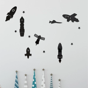Macro detail of black acrylic space-themed wall stickers with rocket and satellite motifs