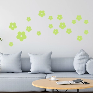 Luminous green flower wall stickers applied above a modern grey sofa for home decor