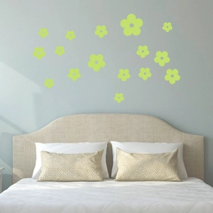 Glow in the dark floral wall stickers applied to a soft bedroom wall surface