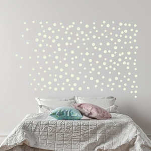 Détail de stickers muraux points ronds lumineux bleus sur un mur de chambre confortable