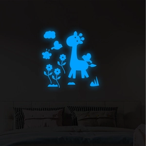 Luminous wall stickers set with giraffe and birds glowing blue in a dark children room