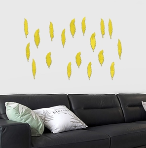 Detail view of yellow feather acrylic mirror wall stickers above a black leather sofa