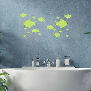 Luminous fish wall stickers in fluorescent green glowing on a bathroom wall background