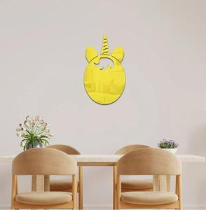 Macro detail of yellow acrylic unicorn mirror wall sticker on a minimalist indoor wall