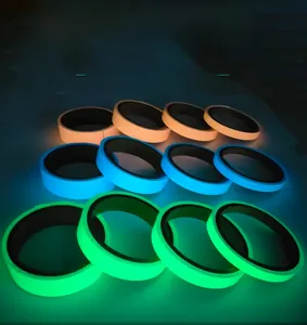 Luminous self-adhesive tape rolls in orange blue and green glowing in dark setting