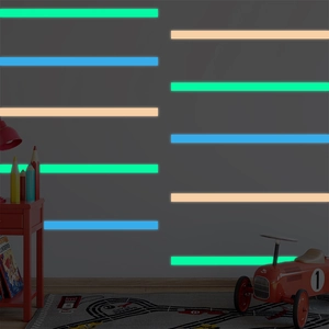 Glow-in-the-dark self-adhesive tape strips in green blue and orange on a wall
