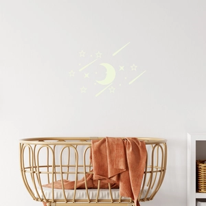 Luminous blue moon and stars wall stickers for nursery decor above a wooden baby crib