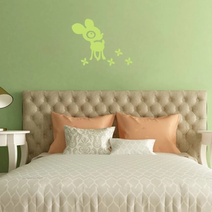 Detailed view of luminous cartoon deer wall stickers on a soft green bedroom wall background