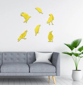 Detailed view of six yellow mirror acrylic crow wall stickers above a modern sofa