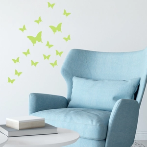Green luminous butterfly wall stickers displayed on a white wall above a blue sofa