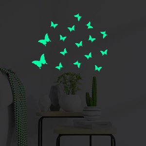 Detailed view of luminous green glow-in-the-dark butterfly wall stickers in a dark room