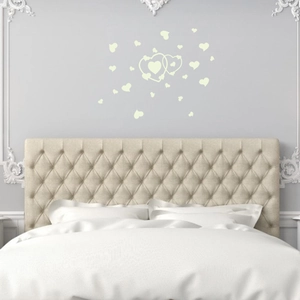 Stickers muraux cœurs fluorescents brillants dans une chambre au-dessus du lit
