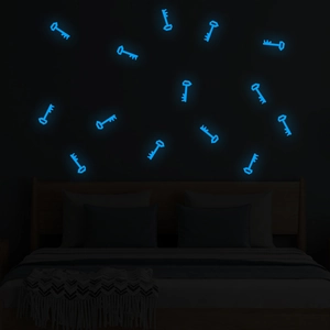 Blue luminous key-shaped wall stickers glowing in the dark on a bedroom wall surface