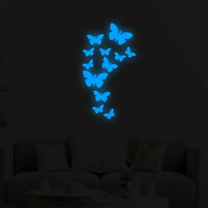 Detailed view of luminous blue butterfly wall stickers glowing in a dark room setting