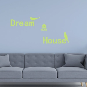 Detailed view of luminous Dream Home lettering and bird wall stickers on a blue wall