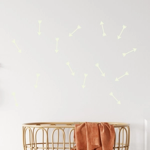 Glow in the dark arrow wall stickers for nursery decor above a woven crib