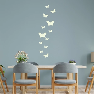 Glow-in-the-dark butterfly wall stickers applied on a blue-grey wall in a dining room