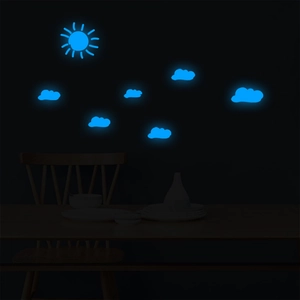 Luminous wall stickers set with sun and clouds glowing blue in a dark bedroom