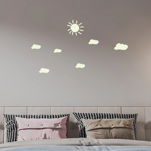 Luminous wall stickers featuring a sun and clouds glowing in a modern bedroom setting