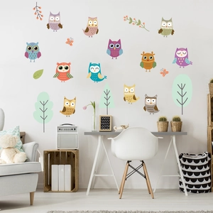 Detailed view of luminous cartoon owl wall decals in a cozy children room setting