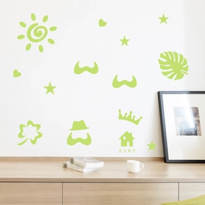 Detail of luminous green wall stickers with sun star heart shapes on a white bedroom wall