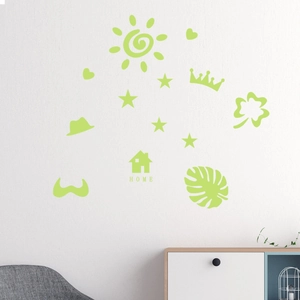 Luminous wall stickers featuring green sun, heart, and home shapes on a white bedroom wall