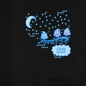 Luminous wall stickers with glowing blue owls and moon in a dark bedroom setting