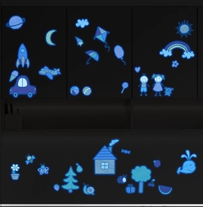 Dettaglio degli adesivi murali luminosi con luna, stelle e razzo che brillano nel buio