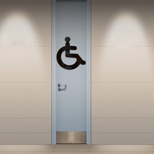 Black acrylic wheelchair access sign for restroom doors in a modern commercial office setting