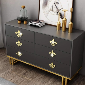 Golden fleur-de-lis drawer pulls set installed on dark grey cabinet for luxury home decor