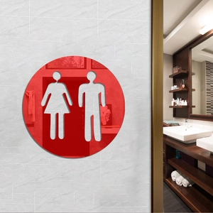 Macro detail of round red mirror acrylic restroom sign with hollow man and woman icons
