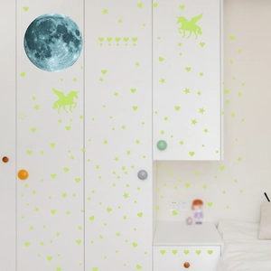 Detailed view of glow-in-the-dark stars, moons, and unicorns on a bedroom wall
