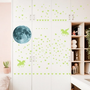 Luminous wall stickers featuring moon, unicorns and stars on a white bedroom cabinet