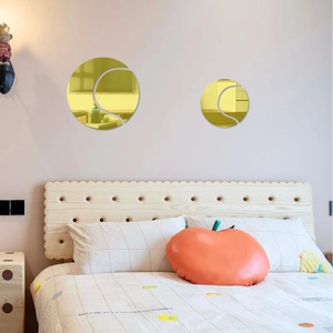 Detailed close-up of golden acrylic tennis ball mirror wall stickers on a bedroom wall
