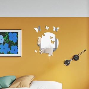 Detailed view of silver butterfly mirror wall stickers on a warm yellow living room wall