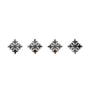 Detail view of four black acrylic mirror corner wall stickers with hollow floral patterns