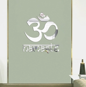 Detailed view of silver mirror acrylic Om Namaste wall sticker on a minimalist green wall