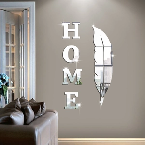 Macro detail of silver 3D mirror HOME wall decals with feather shape on gray wall
