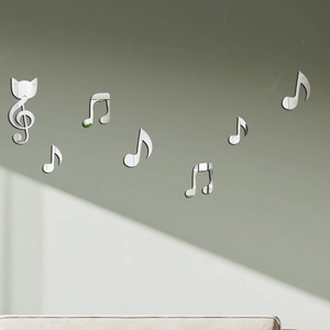 Détail de 7 stickers muraux musicaux en acrylique miroir argenté sur un mur gris épuré