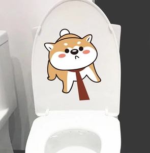 Detail shot of a cute cartoon Shiba Inu sticker applied on a white toilet lid cover