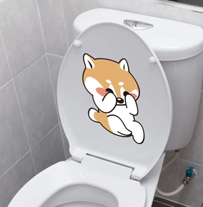 Close-up of cute cartoon Shiba Inu dog sticker applied inside a white toilet lid