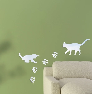 Detail of mirror acrylic cat wall stickers with reflective surface on a green wall