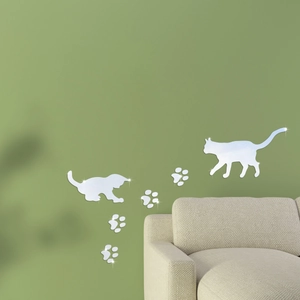 Detail of silver mirror acrylic cat wall stickers on a modern olive green living room wall