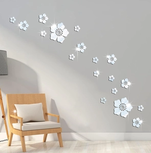 Close-up of light blue 3D mirror flower wall stickers on a modern grey living room wall