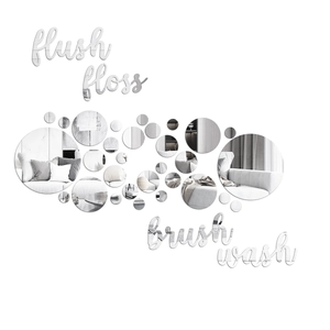 Close-up of silver acrylic mirror wall decals featuring hand-written bathroom words and circles