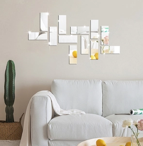 Modern geometric acrylic mirror wall decals arranged over a gray sofa in a living room